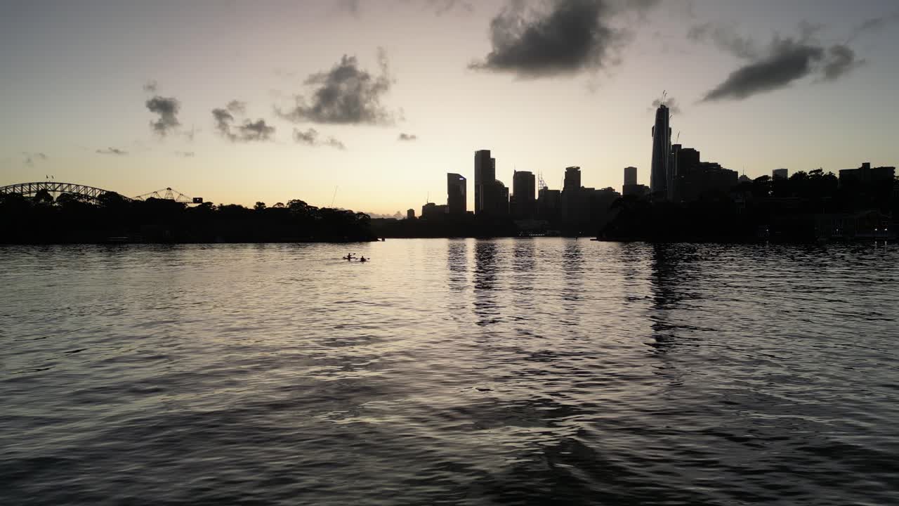 Sydney CBD during Sunset with 2 Kayaks paddeling