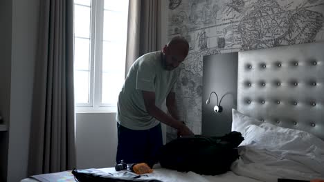 tourist packing his backpack on the bed in a hotel room, getting ready for his next adventure