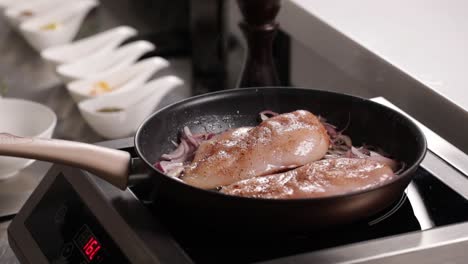 frying chicken breast with red onions