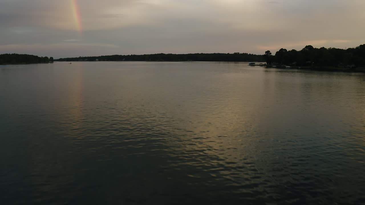 arco iris al atardecer al final de la tarde reflejándose en las tranquilas aguas del lago después del verano una tormenta vista aérea