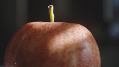 manzana roja girando con una ligera sombra desde la ventana