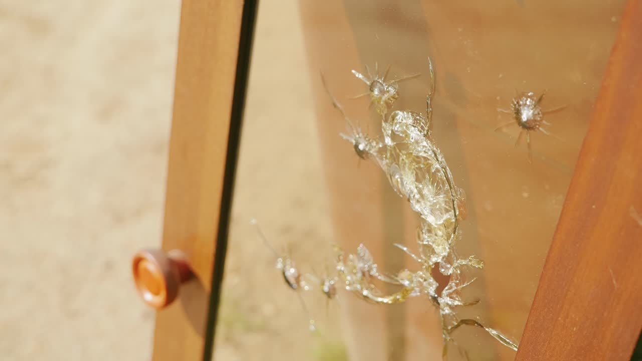 Close up, shattered bulletproof glass door hit by multiple projectiles