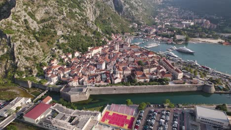 Aerial:-Kotor,-Montenegro-with-citywalls-surrounding-historic-town,-bay-and-mountains