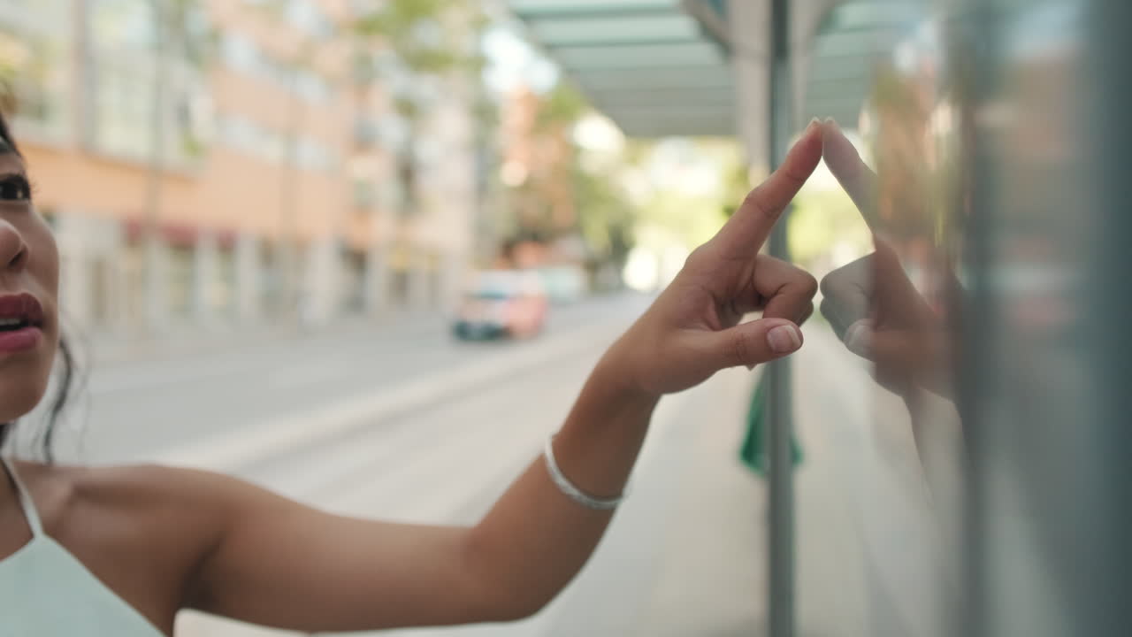 Woman using touchscreen at bus stop