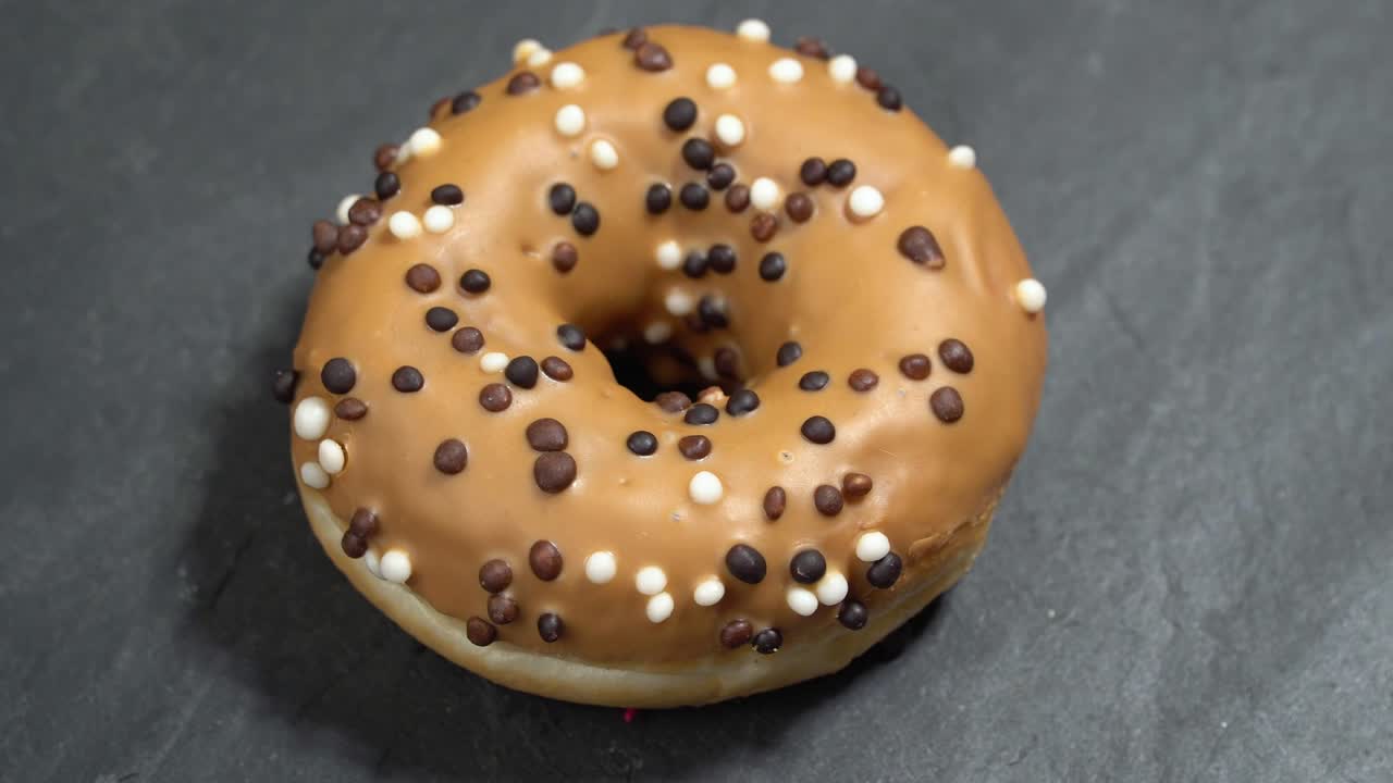 el donut dulce gira sobre un fondo oscuro. la dulzura tradicional estadounidense