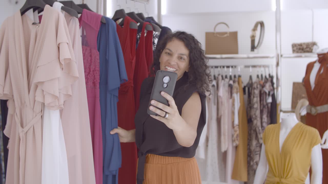 옷가게에서 쇼핑을 하고 친구에게 도움을 요청하는 비디오를 종료한 라틴 여성