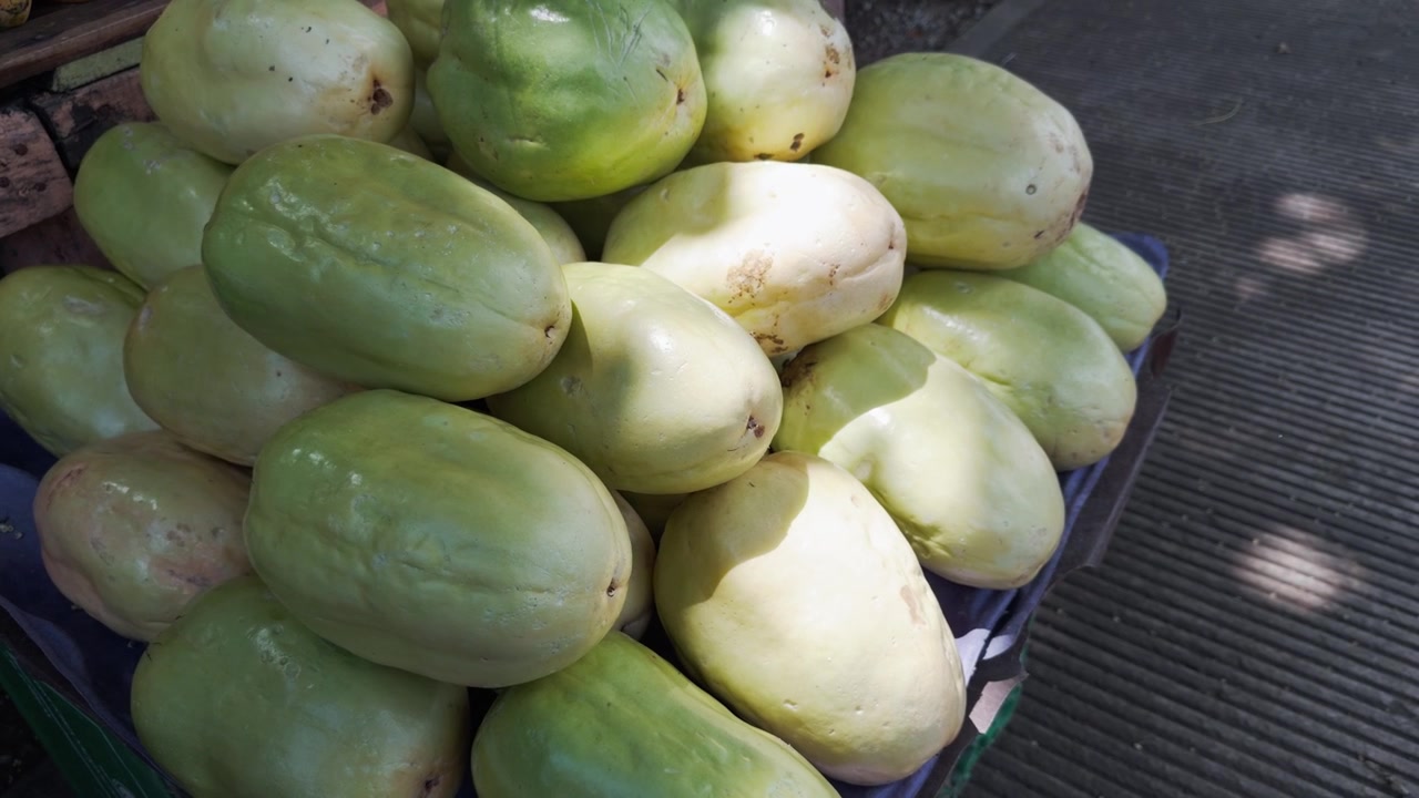 Primo piano di un mucchio di granadille fresche e dolci, un tipo di frutto della passione, in vendita al mercato locale