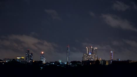 Timelapse-of-a-cloudy-sky-at-night-above-some-buildings-in-Bangkok,-Thailand