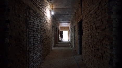 moving by the long corridor in the old building with brick walls. materials for interior works are in the hall.