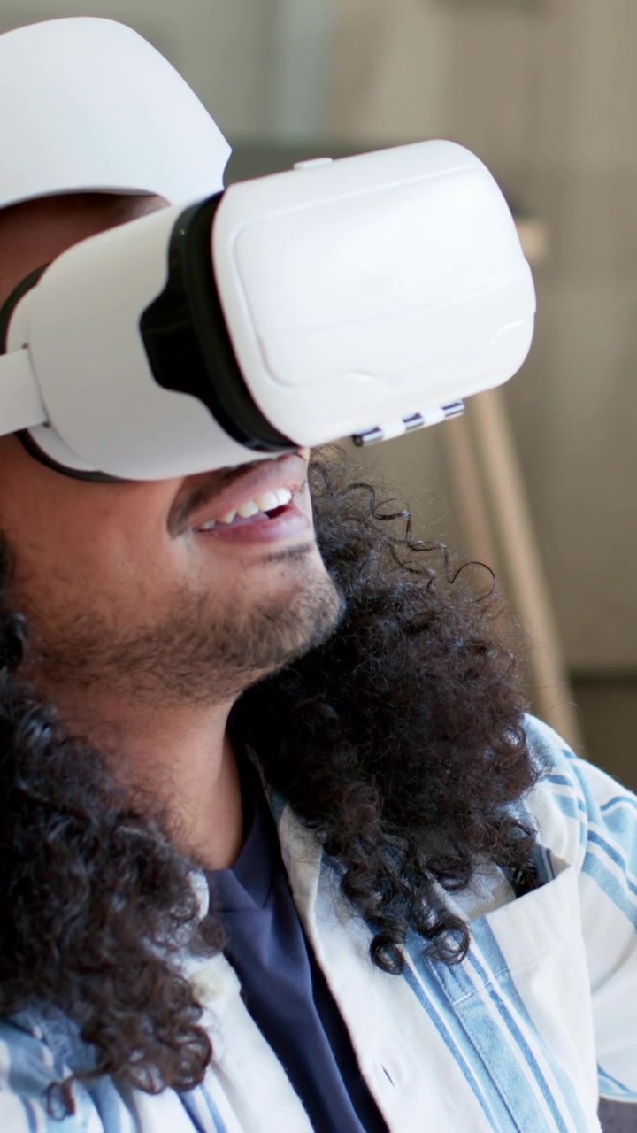 Video verticale: Uomo con visore VR che fa piccoli gesti, attivando un'interfaccia utente virtuale per una demo di design.