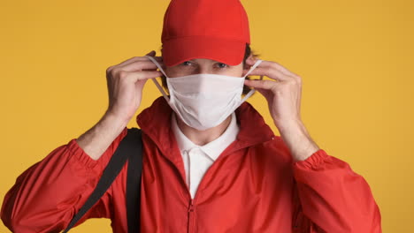 Caucasian-delivery-man-in-front-of-camera-on-yellow-background.