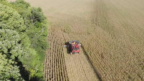 combine harvester collecting grain in a farm field, aerial