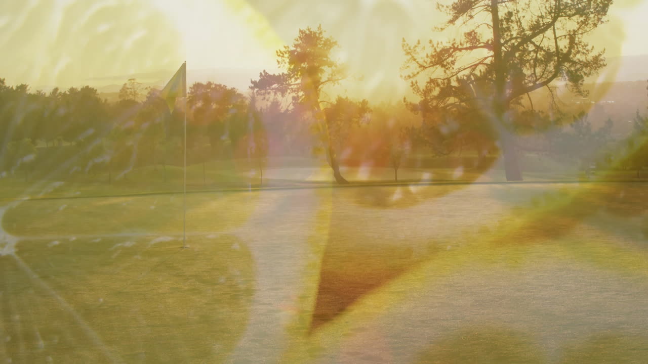 On golf course, sunlit trees and flag with abstract yellow animation shapes