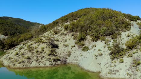 destino de vacaciones tranquilo con aguas tranquilas y claras de un lago de montaña que refleja una vegetación exuberante y un cielo azul