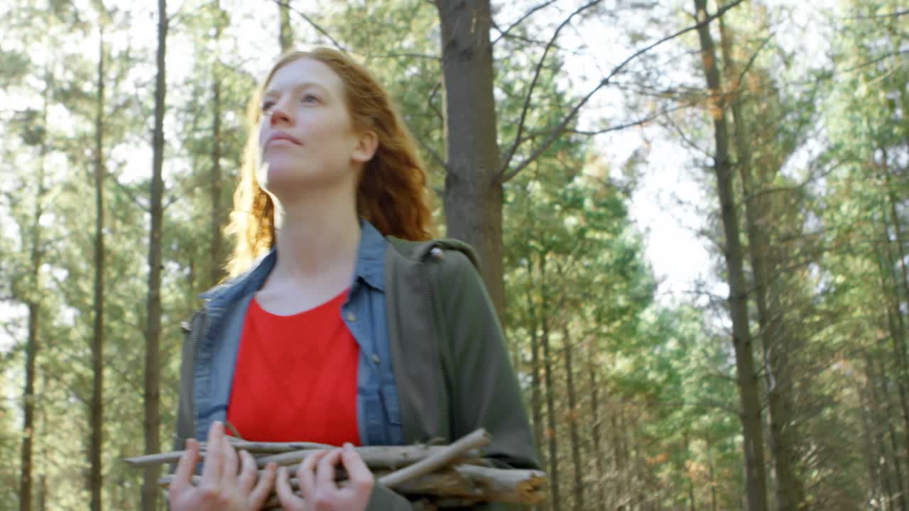mujer caminando con palos de madera en el bosque 4k