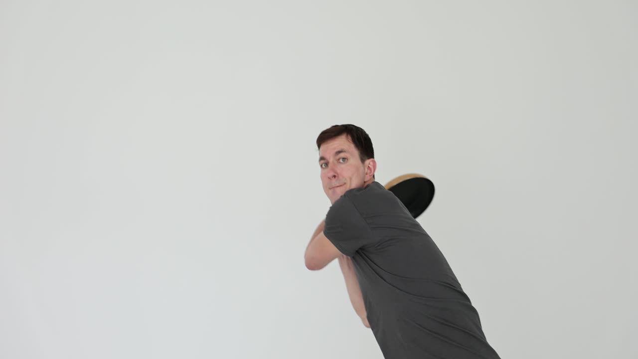 Man Playfully Swings Frying Pan Like a Baseball Bat