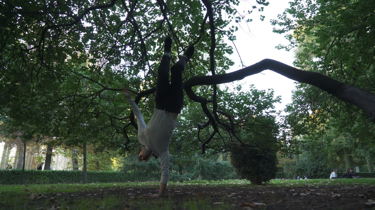 Break dancer practising tricks in the park. On sunset
