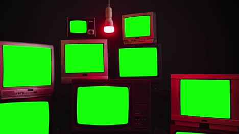 stack of retro vintage tv turning on green screens.