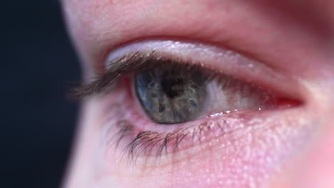 close up of female eye looking at the screen of a smartphone with screen reflecting on eye - macro shot