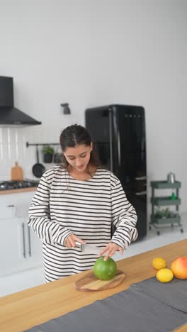 woman cutting a grapefruit in a modern kitchen