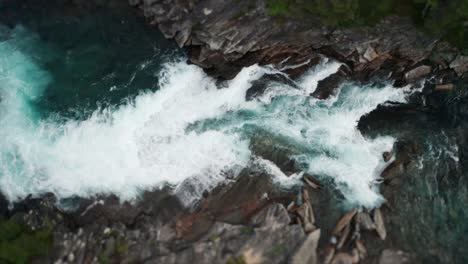 mesmerizing sight - a powerful flow of turquoise water rushing in the narrow and steep rocky riverbed, foaming, splashing, forming whirlpools and eddies on its' way