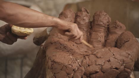 passionate deeply inspired sculptor shaping clay to make ceramic sculpture of human arm. artist in the workshop. work and hobby concept