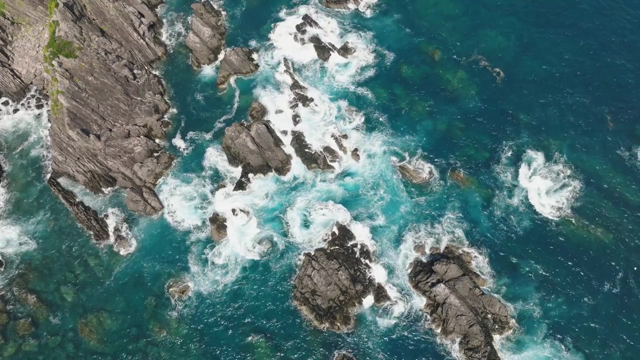 Paesaggio di scogliere ripreso dall'alto nell'Oceano Pacifico giapponese, acqua di mare dell'isola di Shikoku al rallentatore sotto la luce del sole, estate in Giappone.