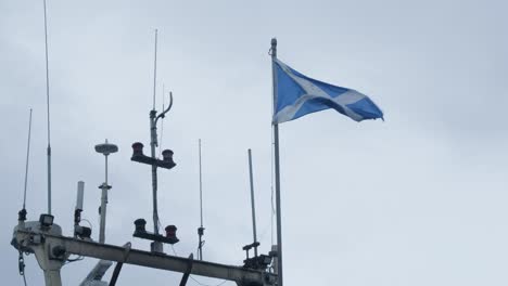 scottish flag blowing on the wind on a boats mast.