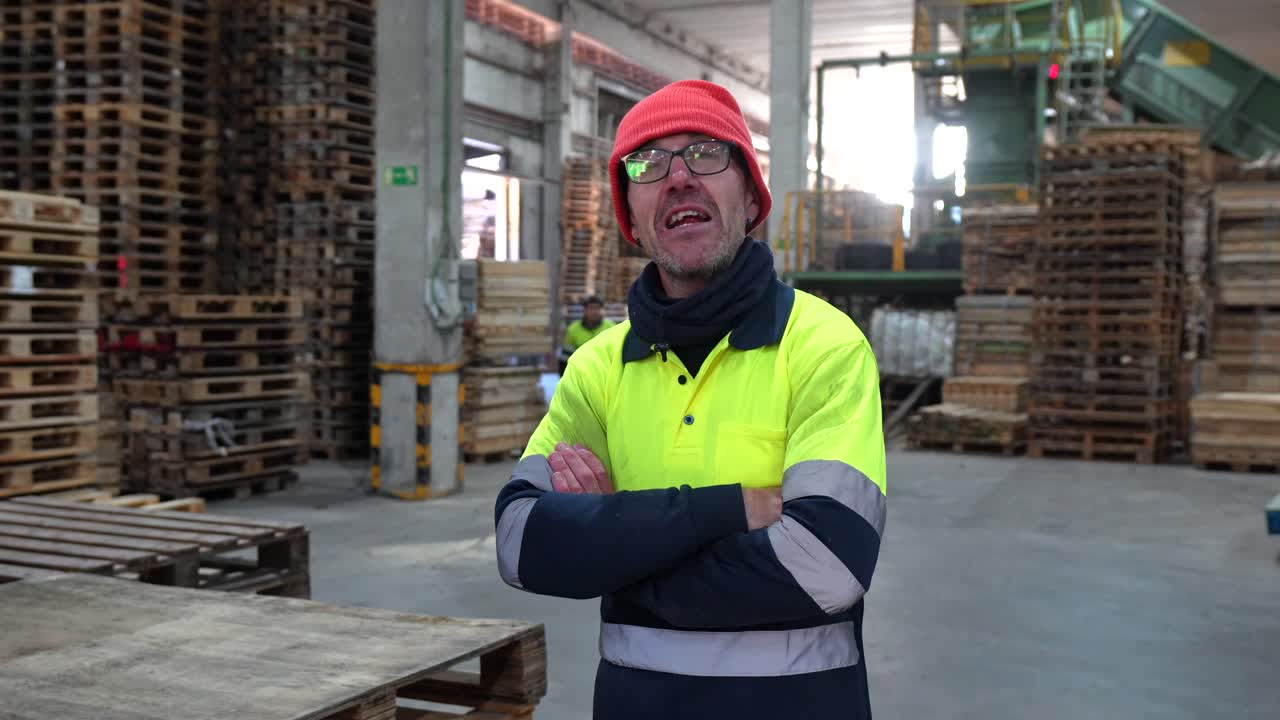Uomo in un magazzino con pallet