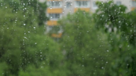 Ventana-Con-Gotas-De-Lluvia-Y-Vista-Al-Bloque-De-Apartamentos