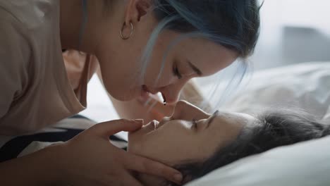 close up video of lesbian couple kissing in the bed.