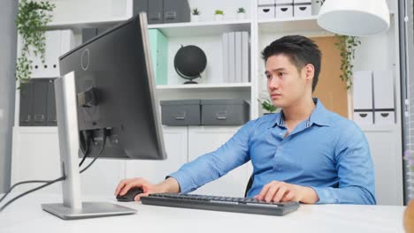 asian handsome business man using laptop computer working in office. attractive professional male employee worker sitting on table, feel happy and enjoy spending leisure time in corporate workplace.