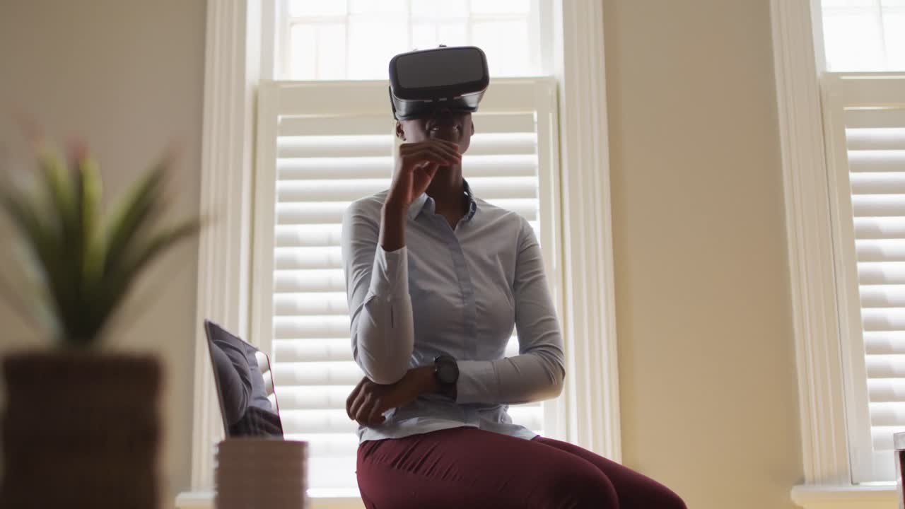 African american woman making hand gestures while using vr headset at home