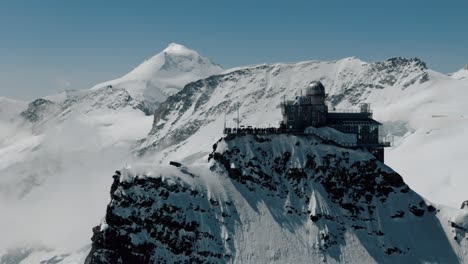 circling right approaching shot of jungfraujoch station with snowy peaks
