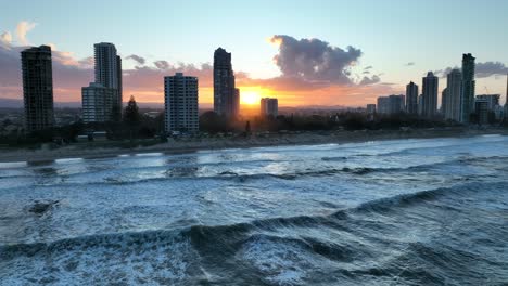 Drone-shot-over-ocean,-stationary,-with-waves-and-sun-reflecting-off-water