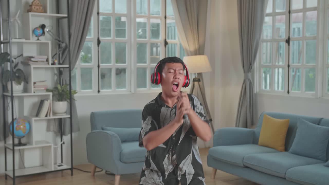 Cheerful Asian Young Boy Listen Music With Headphones, Sing Song In Mobile Phone