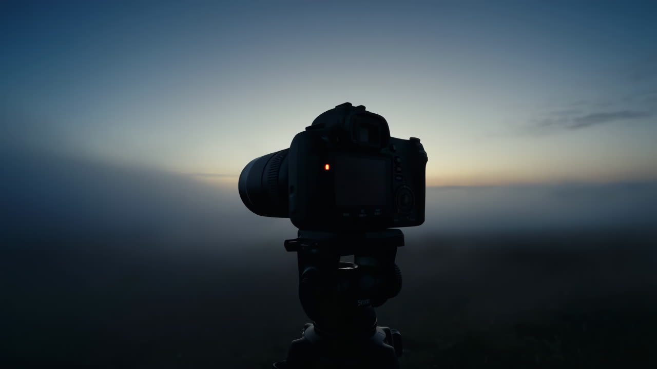 Fotocamera su treppiede al crepuscolo nebbioso