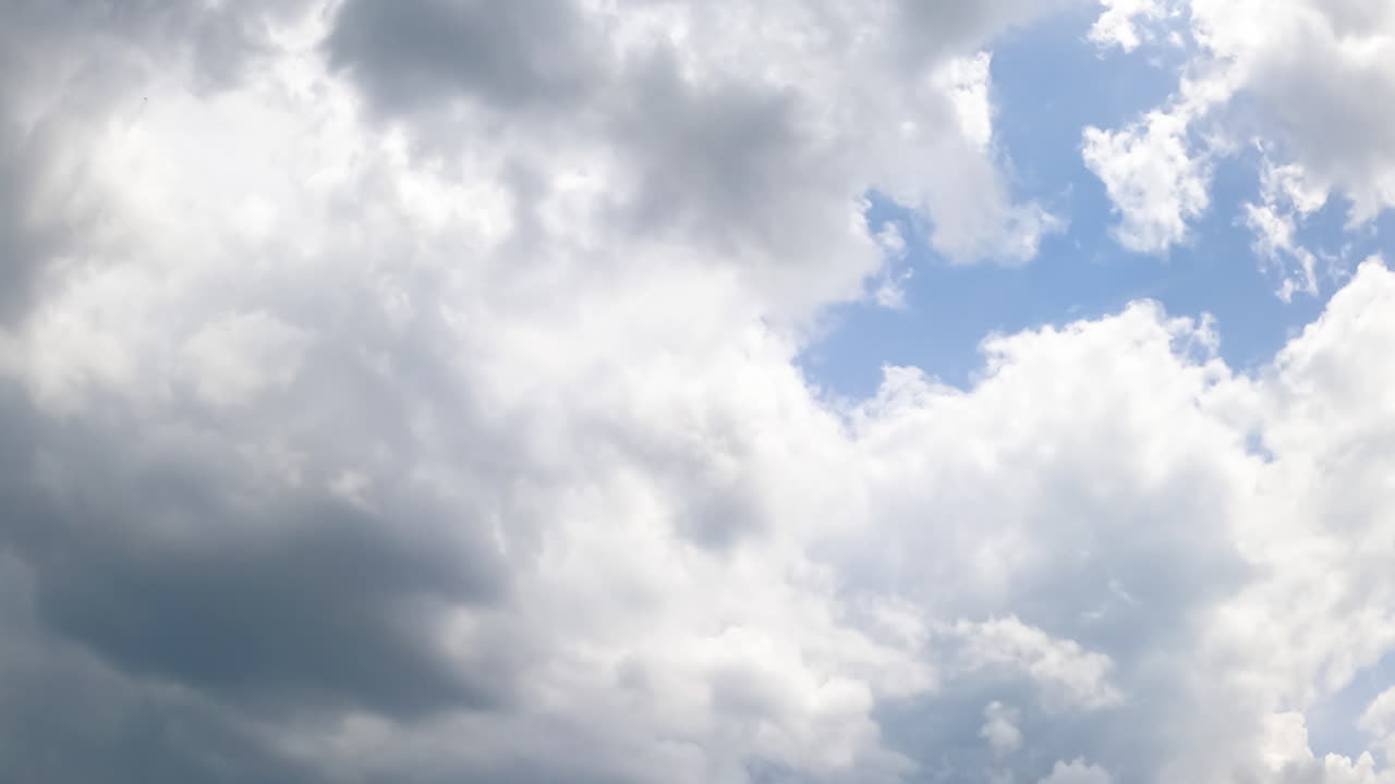 Rainy clouds accumulating in the sky. Dramatic cloudscape formation. Low angle view. Timelapse.