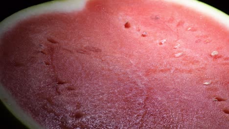 frutas rojas de sandía girando sobre un fondo negro