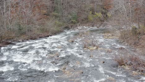 Drohnenaufnahme-Eines-Flusses-In-Geringer-Höhe,-Der-Im-Spätherbst-Im-Westen-Von-North-Carolina-Flussabwärts-Fliegt