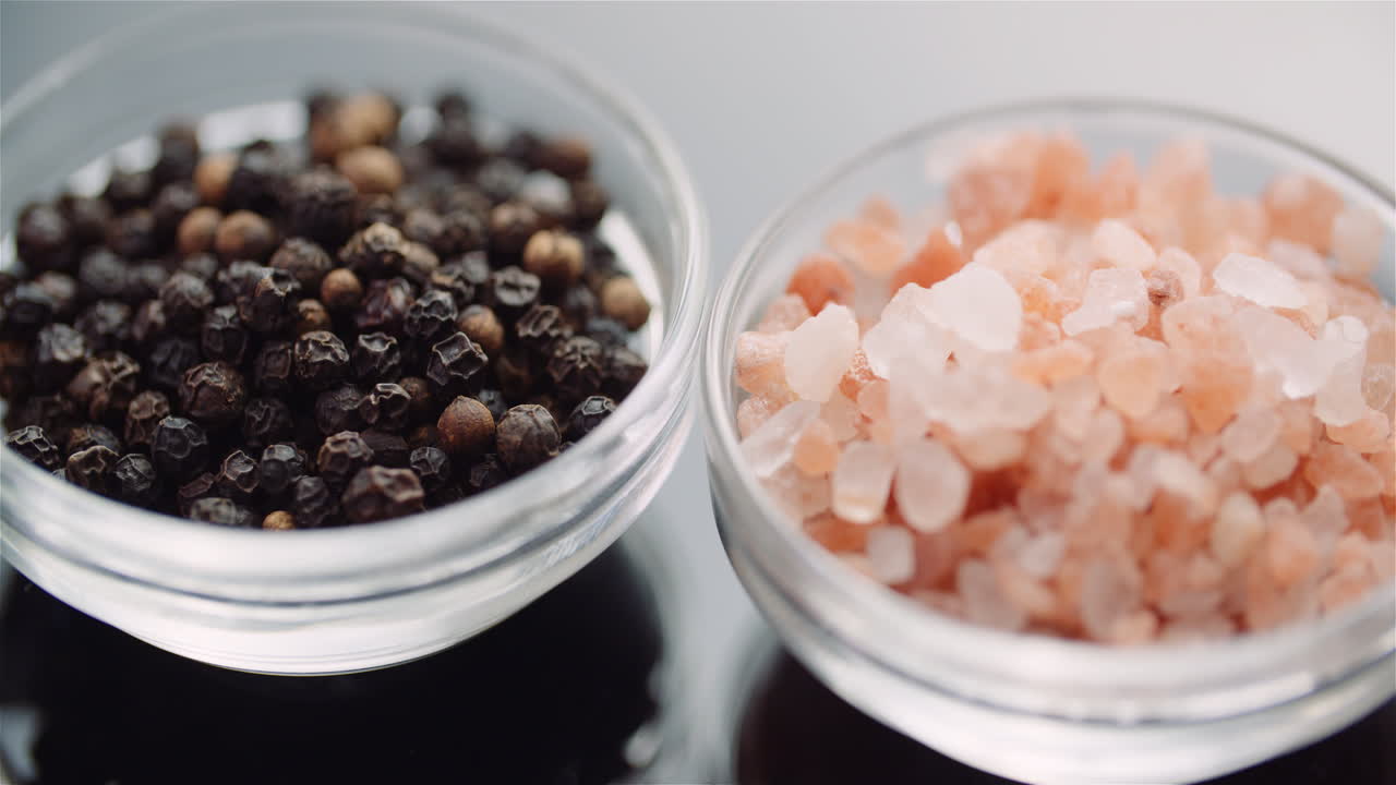 테이블 3에서 회전하는 그릇에 후추와 히말라야 소금