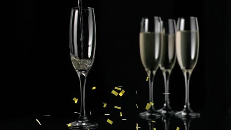 animation of gold confetti falling over glasses of champagne on black background