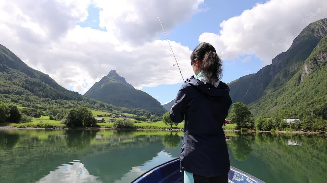 보트에 있는 여자가 노르웨이에서 물고기를 잡습니다.