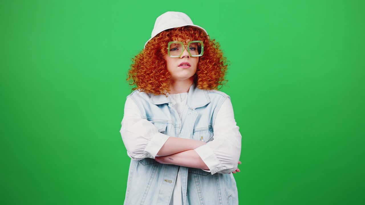Thinking process. Young pensive redhead curly woman wearing panama hat and glasses brainstorming, looking at camera