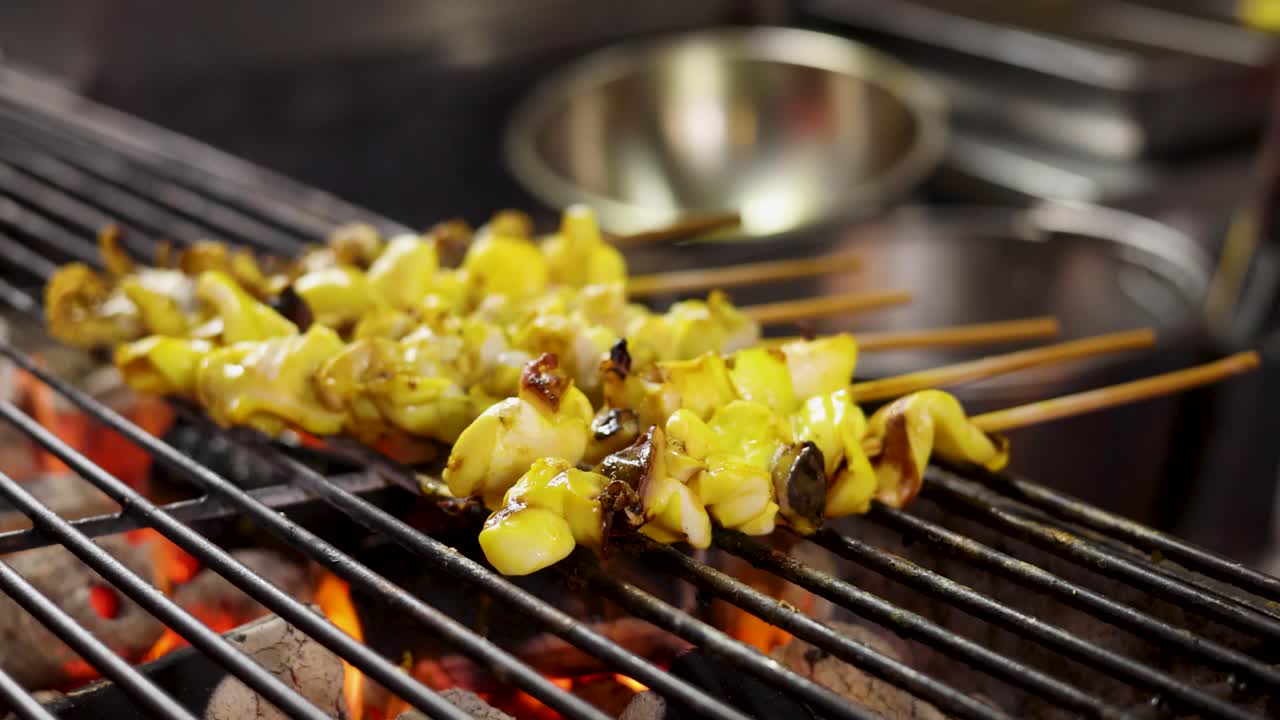 Close-up of squid skewers grilling over open flame, vibrant street food scene, shallow focus