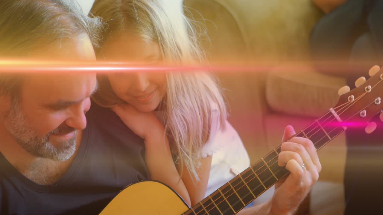 Ojciec prowadzący córkę podczas gry na gitarze, wśród flary obiektywu, pokazującej nakładkę akordów w muzyce.