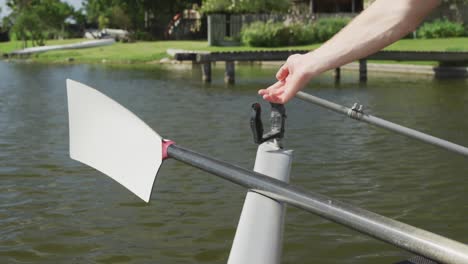 male rower fixing the oar on the boat