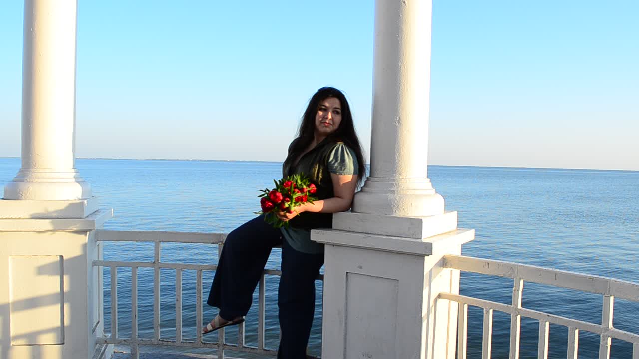 A garota em um arco florido. A garota com flores contra o mar.