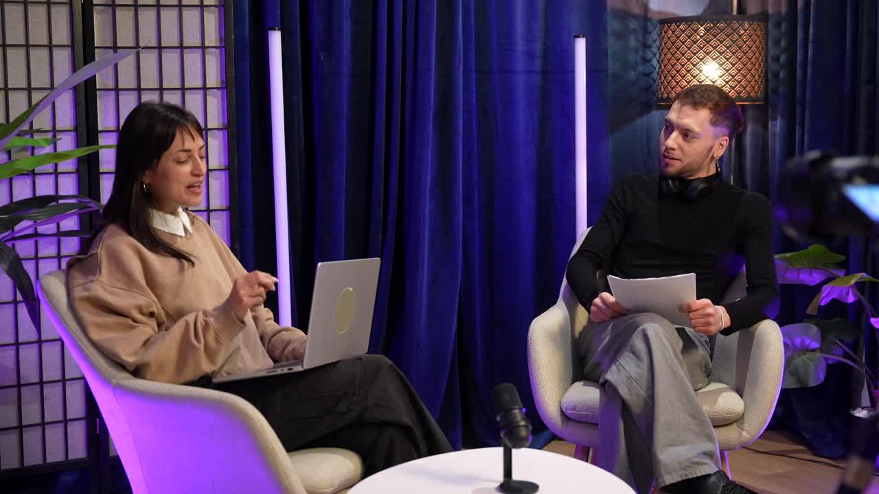 Two Young Adults Recording a Podcast in a Modern Studio