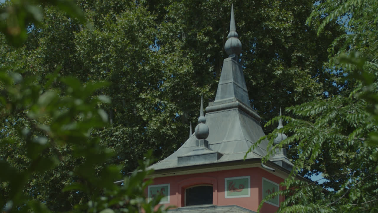 Ornate architectural turret amidst lush green trees